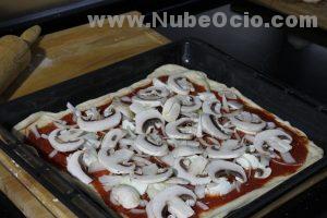 Echando champiñones a la pizza