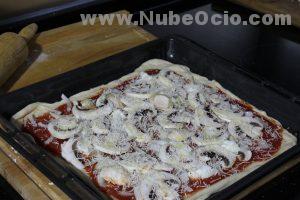 Echando parmesano a la pizza