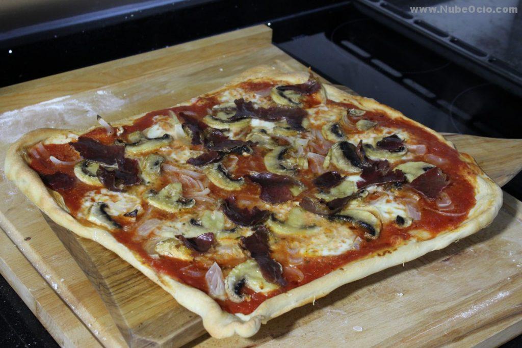 Pizza cocida, con tomate, ajo, orégano, mozzarella, cebolla, champiñones, aceite de oliva y cecina